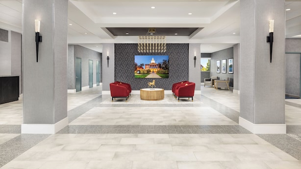 A spacious lobby with a central seating area, a large wall-mounted artwork, and a modern ceiling design. - DoubleTree by Hilton Downtown Concord (Concord)