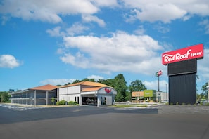 A Red Roof Inn with a large sign, a parking lot, and a building with a red roof. - Red Roof Inn Manchester, TN (Manchester)