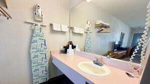 A bathroom with a sink, mirror, towel rack, and a shower curtain with text.