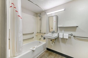 Un baño con bañera, lavamanos y ducha.