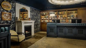 Una biblioteca con estanterías, chimenea y un espacio de escritorio.