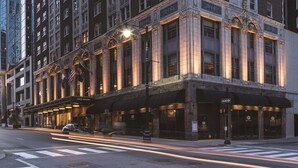 A historic building with ornate architectural details, a prominent entrance, and a street view.