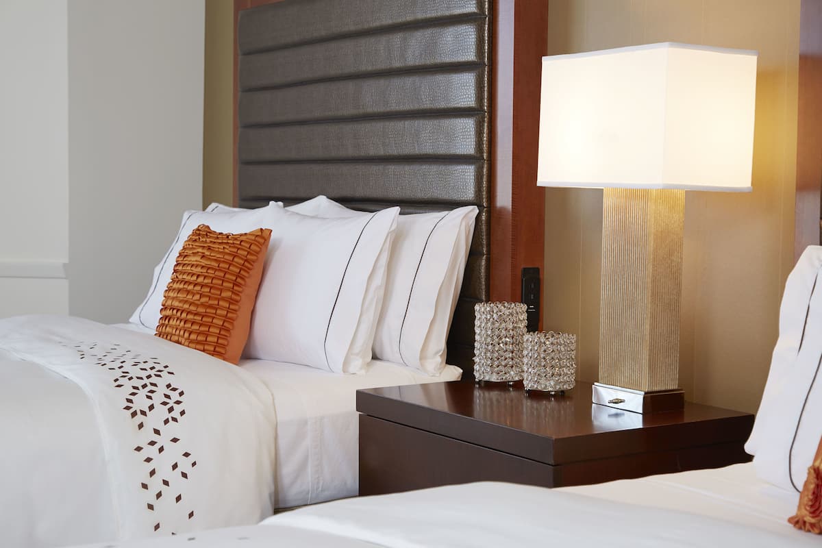 Ein Hotelzimmer mit Bett, Nachttisch, Lampe und Dekoration.