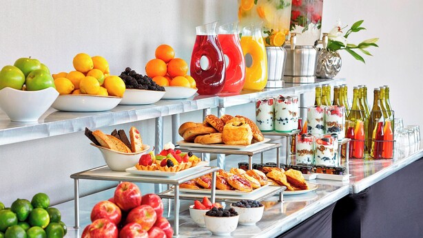 Een buffet met fruit, gebak en drankjes.