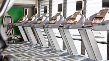 A row of treadmills with digital displays, arranged in a gym setting.