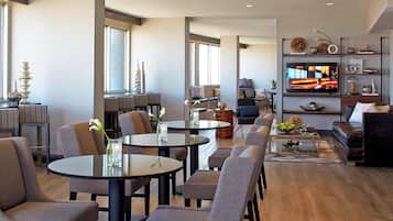 Una sala de estar moderna con un televisor de pantalla plana grande, asientos cómodos y una mesa de centro.