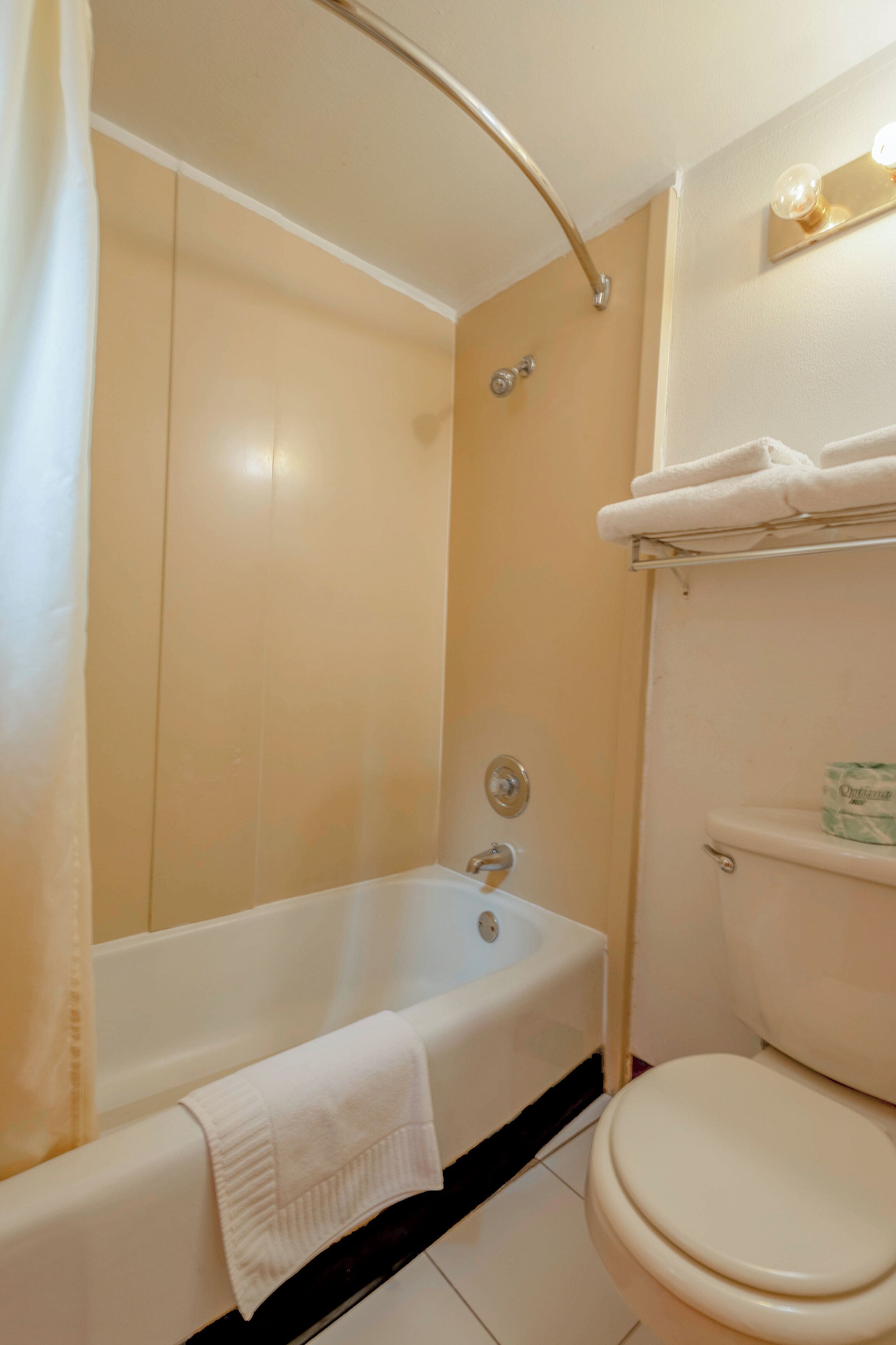A bathroom with a bathtub, toilet, and a towel rack.