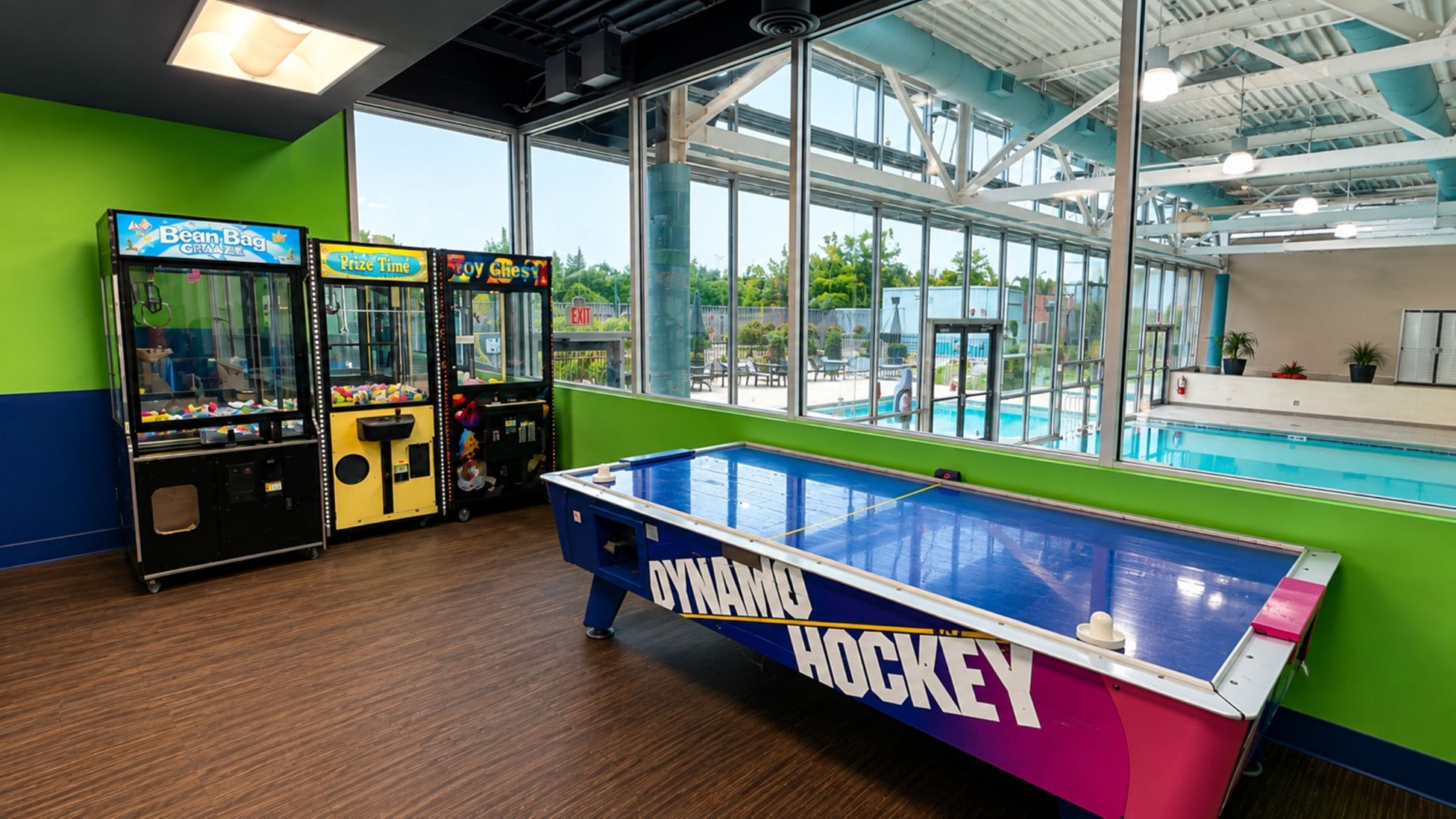 Un espace de loisirs intérieur comprenant une table de baby-foot portant l’inscription « DYNAMO HOCKEY » et des jeux d’arcade, notamment « Prize Time » et « Toy Chest ».
