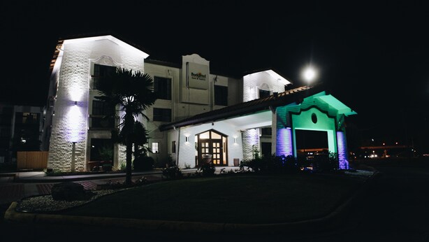 A hotel with a prominent entrance, a stone facade, and a sign reading "Budgettel." - All Seasons Inn & Suites (Memphis)