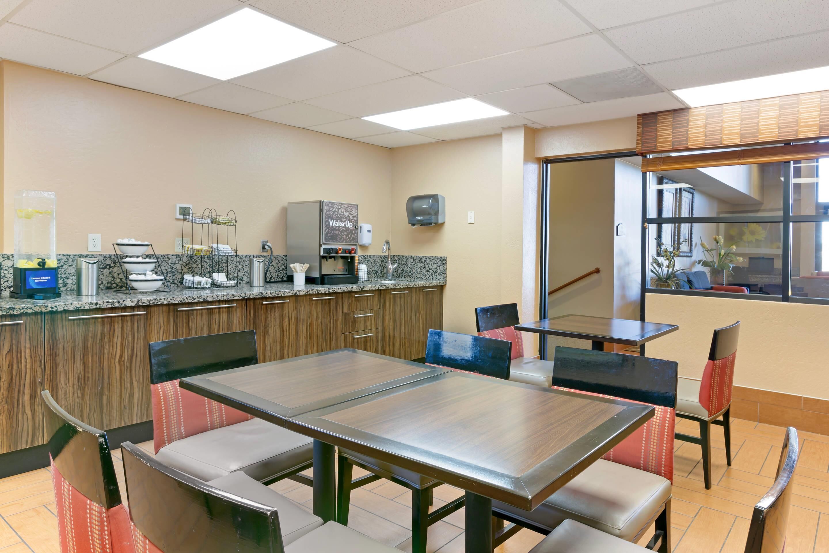 A clean, well-lit indoor space with a kitchenette, seating area, and a view of the outside.