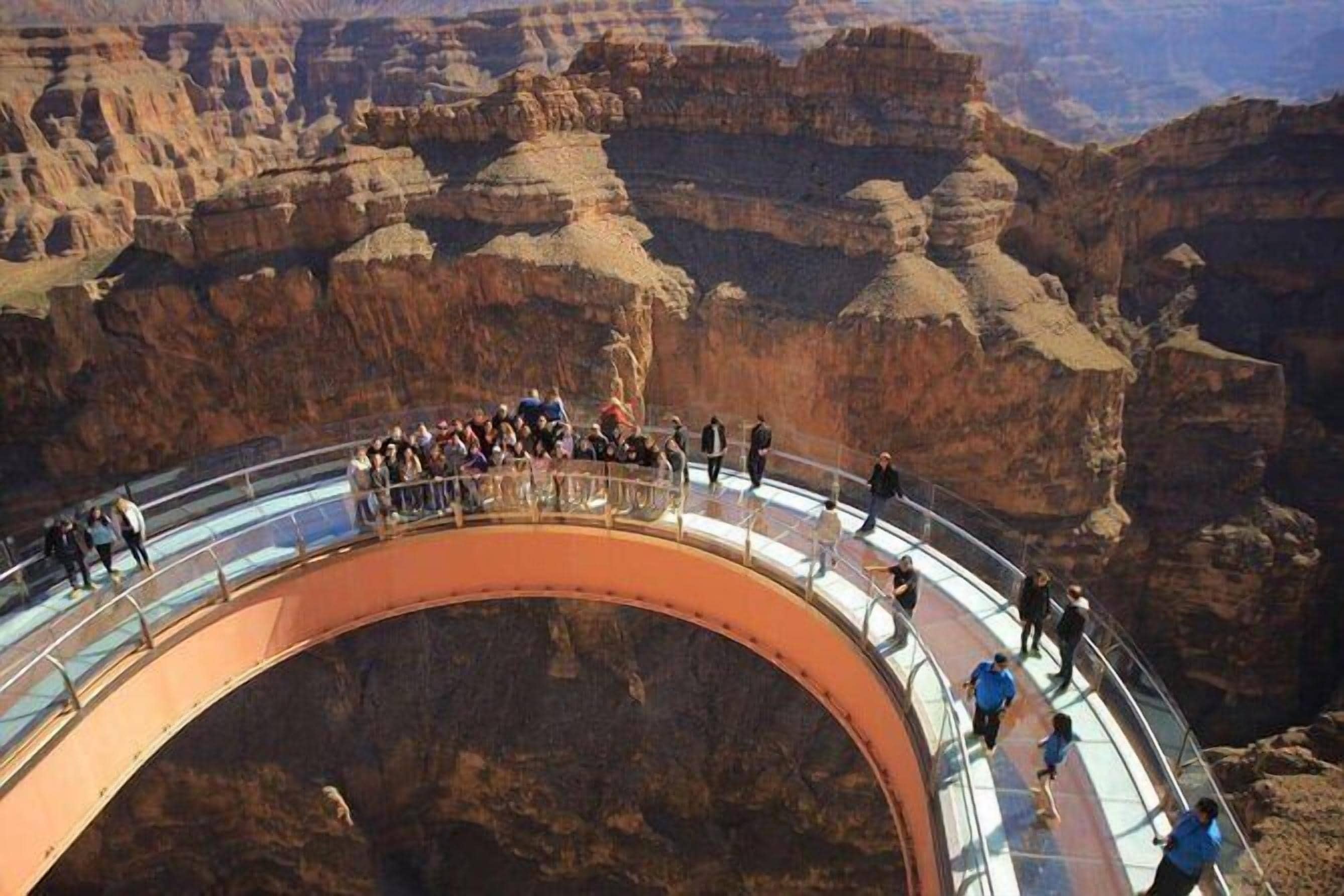 Un pont de verre sur lequel des personnes se promènent au-dessus d’un canyon.