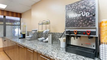 A coffee station with a 'Wake Up' sign, a water dispenser, and a coffee machine.