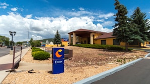 A hotel entrance with a blue 'Enter' sign, a covered outdoor area, and a clear sky.