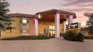 A Comfort Inn hotel with a covered entrance, a gravel driveway, and a signboard. - Comfort Inn Near Grand Canyon (Williams)