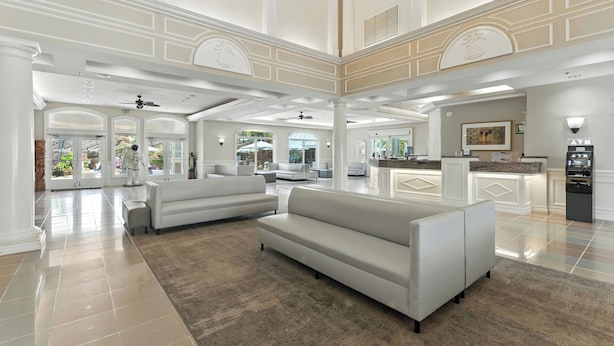 A spacious lobby with a high ceiling, white sofas, a kitchen area, and an ATM. - Radisson Resort at the Port (Cape Canaveral)