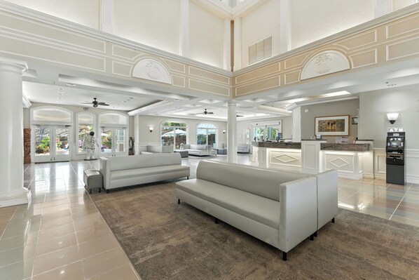 A spacious lobby with a high ceiling, white sofas, a kitchen area, and an ATM. - Radisson Resort at the Port (Cape Canaveral)