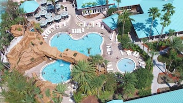 Relax by the heart-shaped pool surrounded by lush greenery and palm trees, with sun loungers and umbrellas at your disposal.