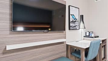 Un baño moderno con un espejo grande, un lavamanos, una silla y un banco.