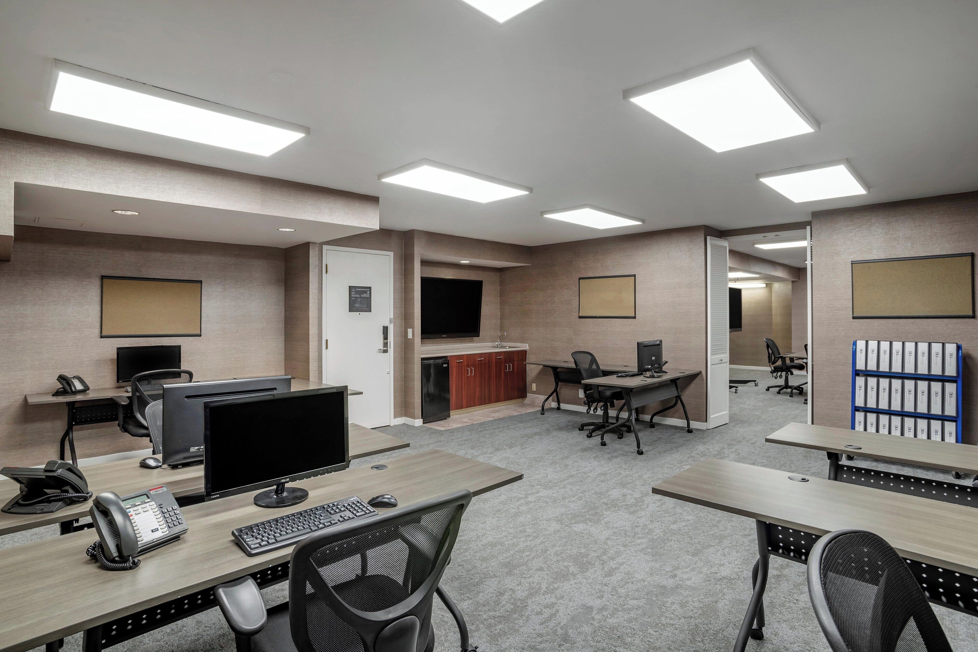 A modern office space with desks, computers, and chairs.