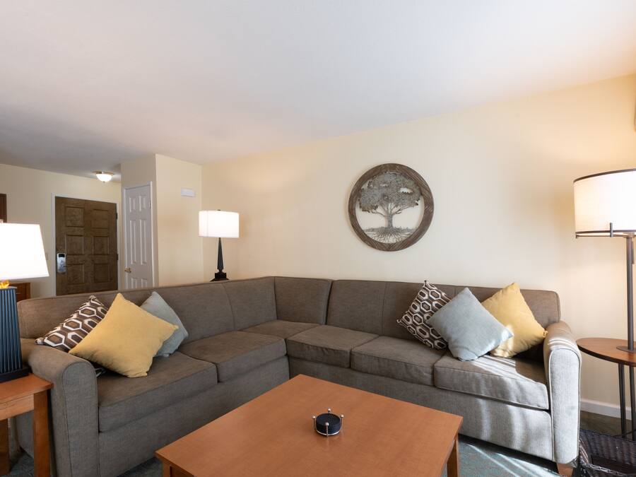 A living room with a sectional sofa, a coffee table, and a lamp.