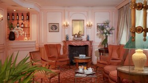 Quarto com lareira, área de estar e bar com garrafas.