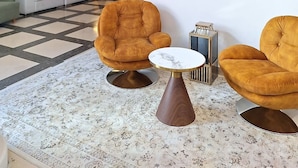 A modern living room with a sofa set, two armchairs, a coffee table, and a decorative wall piece. - Le Cetai Cannes Beach Hotel (Cannes)