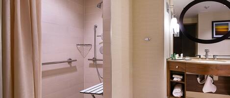 A modern bathroom with a shower, a vanity with a mirror, and a towel rack.