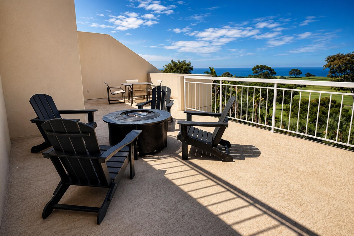 A balcony with outdoor furniture, a round table, and a view of the ocean.