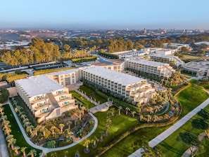 A modern hotel complex with multiple buildings, landscaped gardens, and a clear view of the surrounding cityscape. - Hilton La Jolla Torrey Pines (La Jolla)