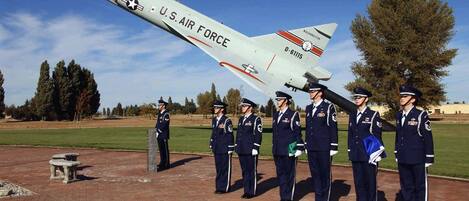 Un avión de combate de la Fuerza Aérea de EE. UU. estacionado en una pista de aterrizaje, con un grupo de personal uniformado de pie en formación.
