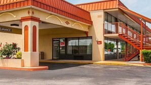 A hotel with a red roof, a covered entrance, and a staircase leading to an upper level. - Econo Lodge Dyersburg I-155 (Dyersburg)
