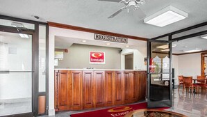 A hotel registration area with a reception desk, a ceiling fan, and a glass partition. - Econo Lodge Dyersburg I-155 (Dyersburg)