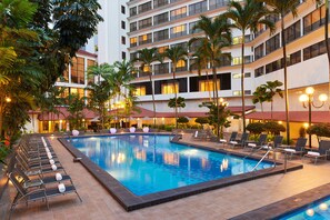 A hotel pool area with multiple lounge chairs and a swimming pool. - York Hotel (Singapore)