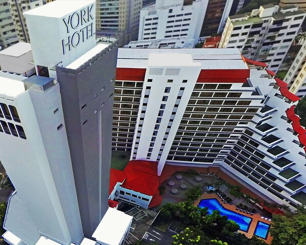 A high-rise hotel with a prominent 'YORK HOTEL' sign, multiple floors, and a pool area with lounge chairs.