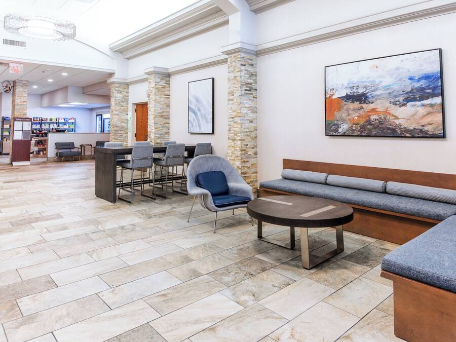 A lobby with a stone floor, seating area, and a large abstract painting on the wall.