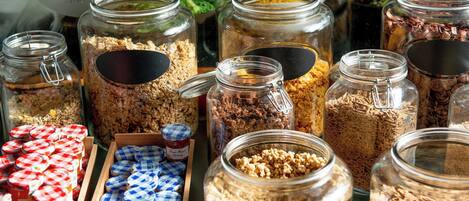 A variety of food items in glass jars and containers, likely for a buffet setting.