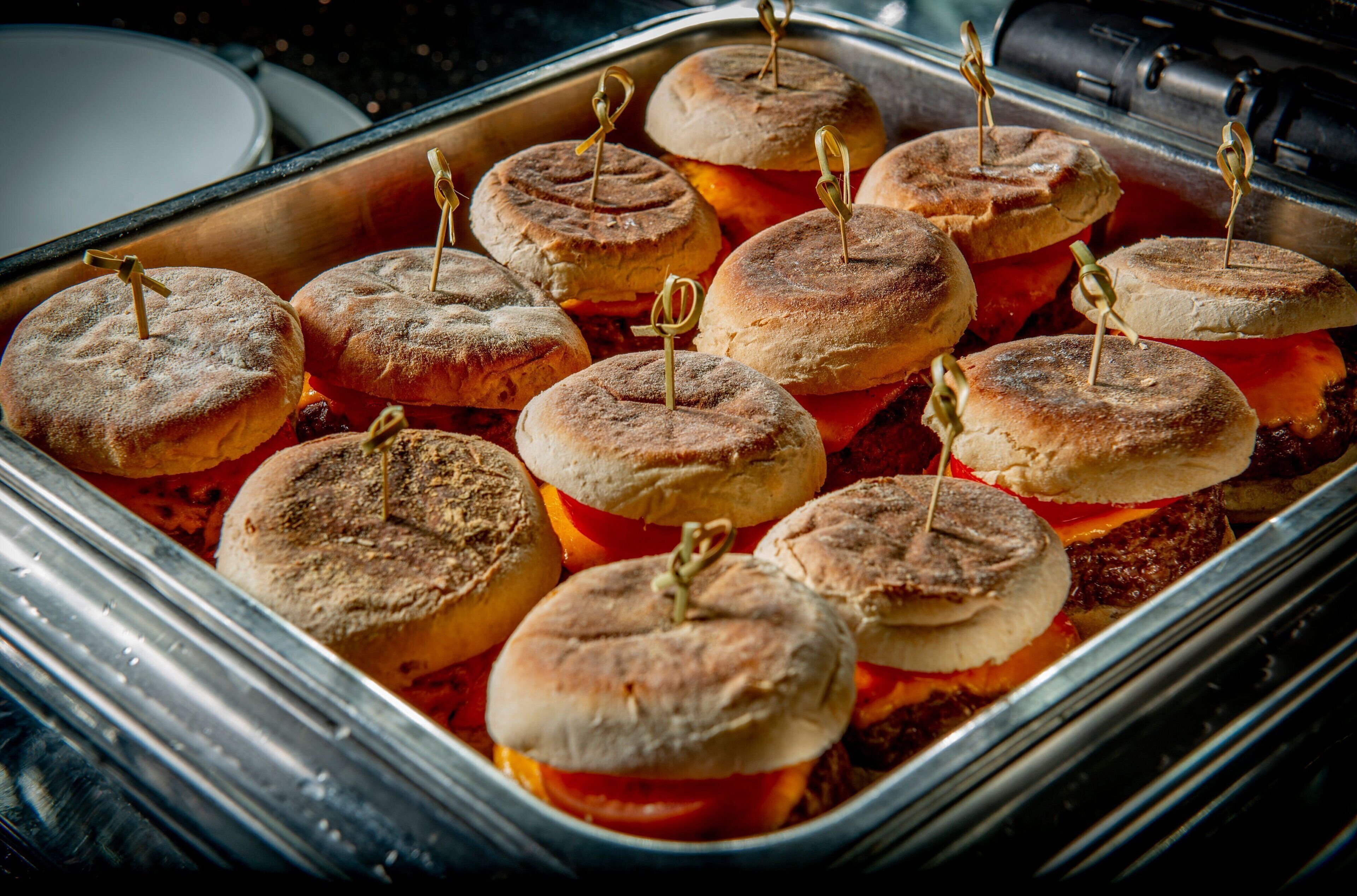 En bakke med sandwicher og tandstikkere på en metalreol.