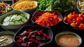 A variety of food items including vegetables, salads, and dips arranged on a table.
