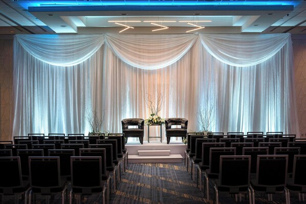 Formal event space with a central stage and elegant drapery, perfect for presentations and gatherings.