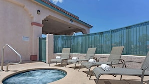 Zona de piscina con sillones de descanso y jacuzzi.