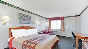 Una habitación de hotel con una cama grande, un escritorio, una silla y dos lámparas.