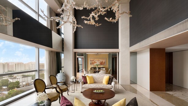 A spacious living area with a high ceiling, large windows, and a view of the cityscape. - Shangri-La Beijing (Beijing)