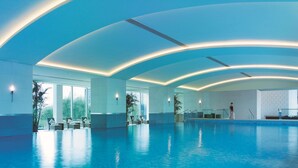 A spacious indoor swimming pool with a modern design, featuring curved ceiling lights and large windows. - Shangri-La Beijing (Beijing)