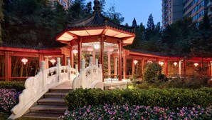 A traditional Chinese pavilion with a stone staircase leading up to it, surrounded by lush greenery and pink flowers. - Shangri-La Beijing (Beijing)