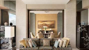A modern living room with a sofa, a coffee table, and a dining area with chairs and a table.