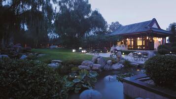 A traditional-style building with a pond and seating area.