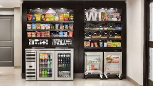 Un espace proposant des distributeurs automatiques de collations, avec un assortiment varié de produits et une section réfrigérée.