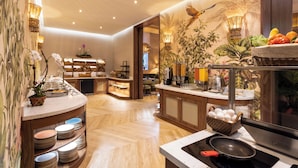 A modern kitchen with a wooden herringbone floor, a central island with a sink, and a breakfast bar with a fruit basket. - The Palms Hotel & Spa (Miami Beach)