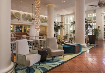 A pathway leading to a gated entrance with palm trees and a building in the background. at The Palms Hotel & Spa