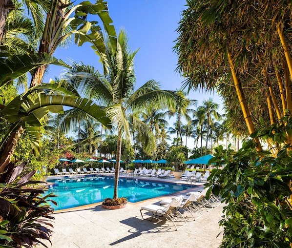 Una piscina al aire libre, una piscina climatizada, sombrillas